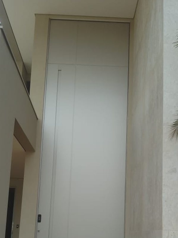 Porta de ACM clara piso-teto em corredor externo de residência em Brasília