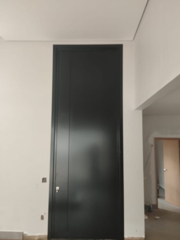 Porta de ACM preta piso-teto acompanhando o pé-direito, executada pela Aluart