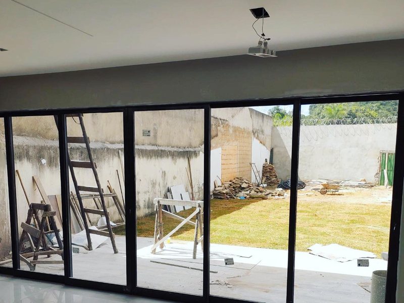 Porta de correr panorâmica em alumínio preto instalada pela Aluart