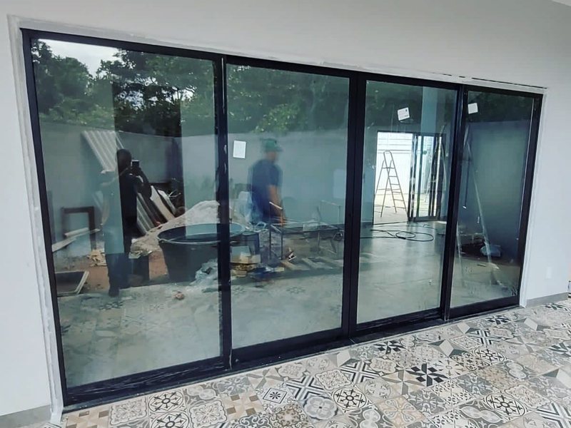 Porta de correr de 4 folhas em alumínio preto instalada pela Aluart