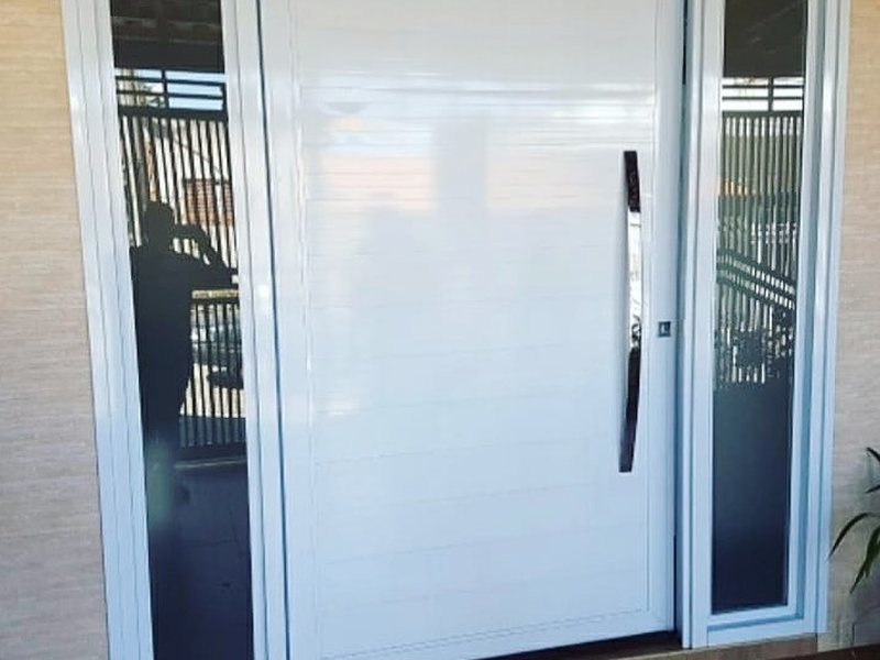 Porta de alumínio branco com bandeira e vidro instalada pela Aluart